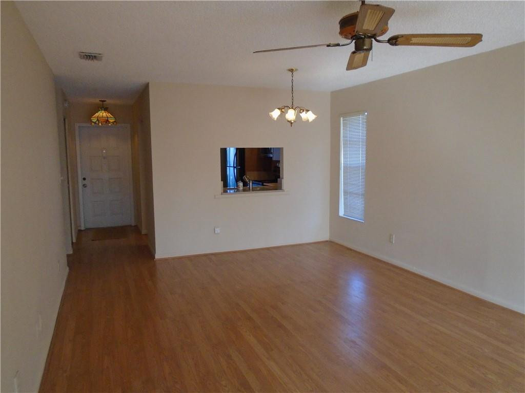 533 Banks Road Margate, FL 33063 - Photo 8 of 31 an empty room with wooden floor chandelier fan and closet