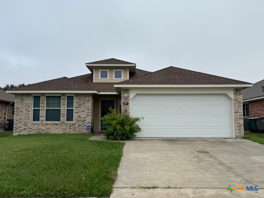 a front view of a house with a garden and yard