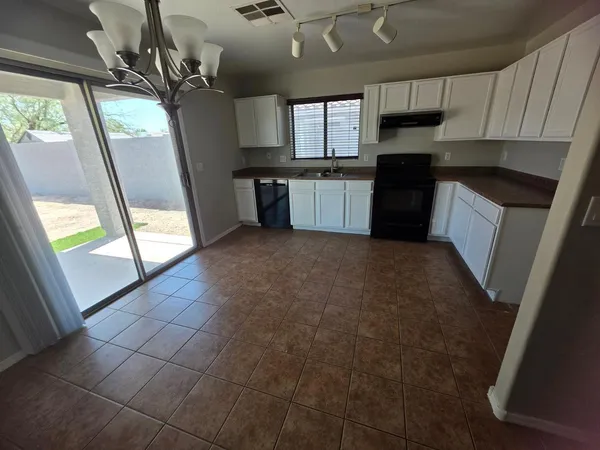 a kitchen with stainless steel appliances granite countertop a refrigerator a sink a stove a microwave and window