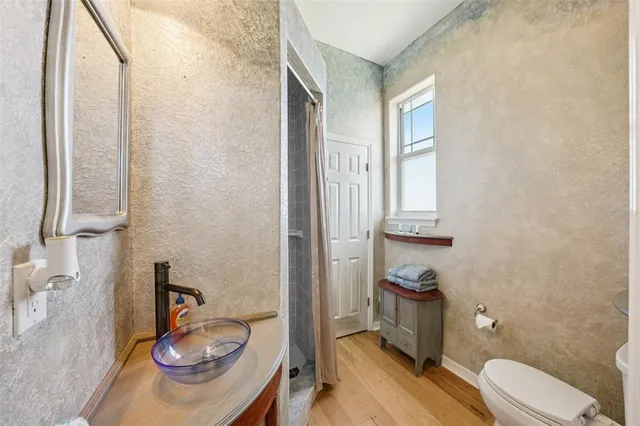 a view of a balcony with wooden floor chairs and iron fence