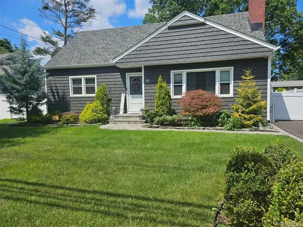a front view of a house with a garden and plants
