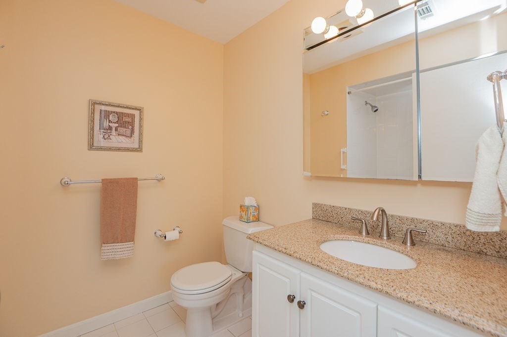 1006 Paradise Road, Unit PHO Swampscott, MA 01907 - Photo 11 of 27 a bathroom with a granite countertop sink toilet and a mirror
