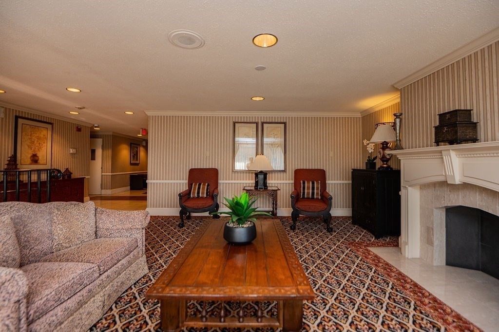 1006 Paradise Road, Unit PHO Swampscott, MA 01907 - Photo 23 of 27 a living room with furniture a fireplace and a flat screen tv