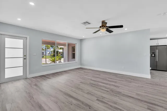 an empty room with wooden floor and cabinet