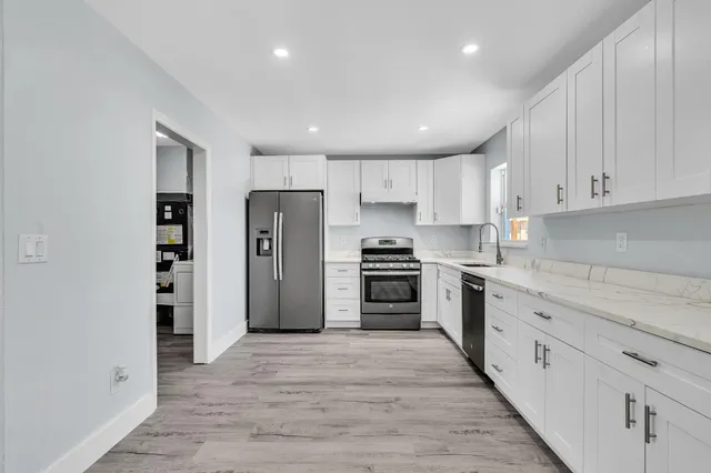 a kitchen with stainless steel appliances a stove a sink and a refrigerator