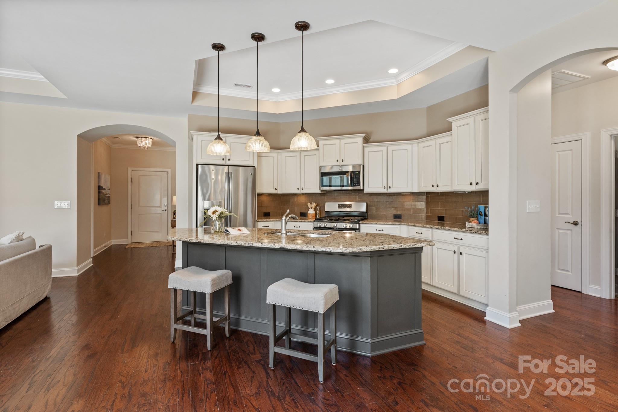 1128 Avalon Place Matthews, NC 28104 - Photo 11 of 39 a kitchen with kitchen island granite countertop a sink cabinets and wooden floor