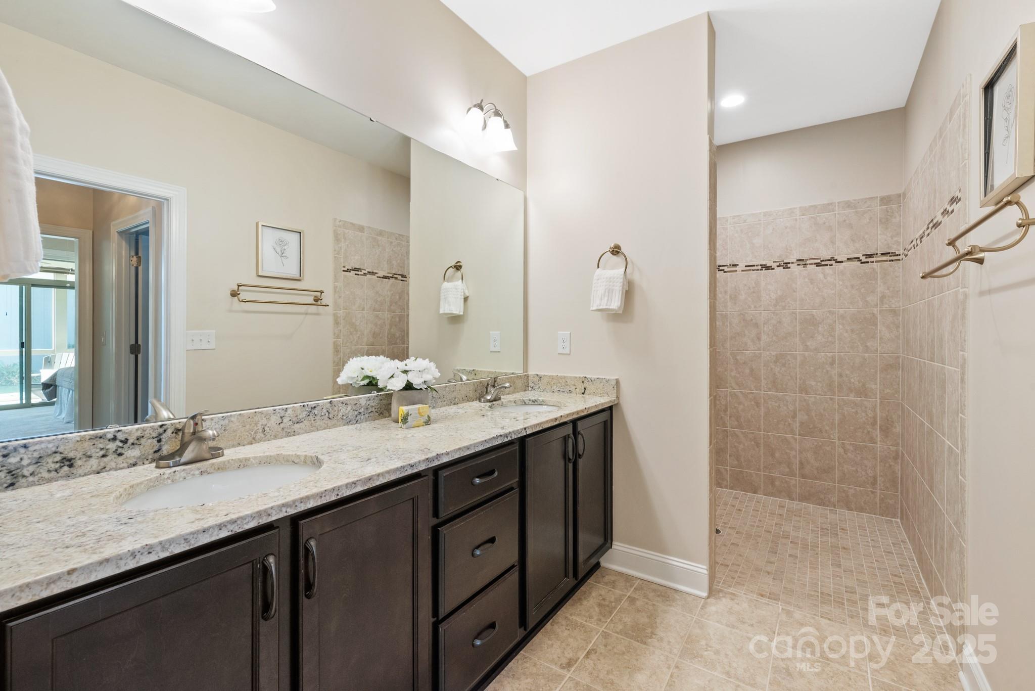 1128 Avalon Place Matthews, NC 28104 - Photo 22 of 39 a bathroom with a granite countertop sink a large mirror and a shower