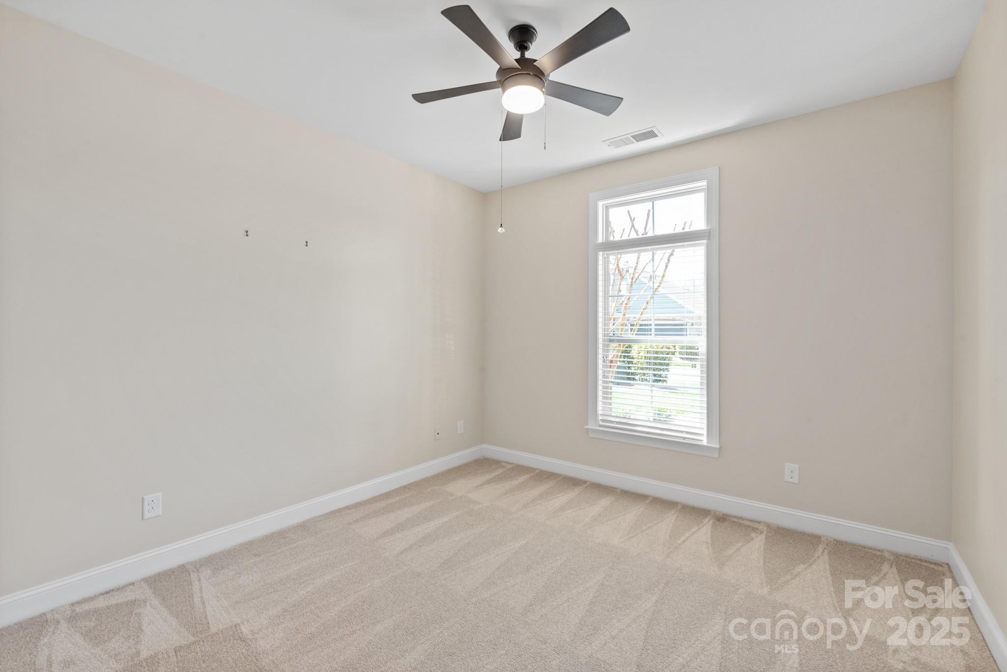 1128 Avalon Place Matthews, NC 28104 - Photo 25 of 39 an empty room with a window and a fan