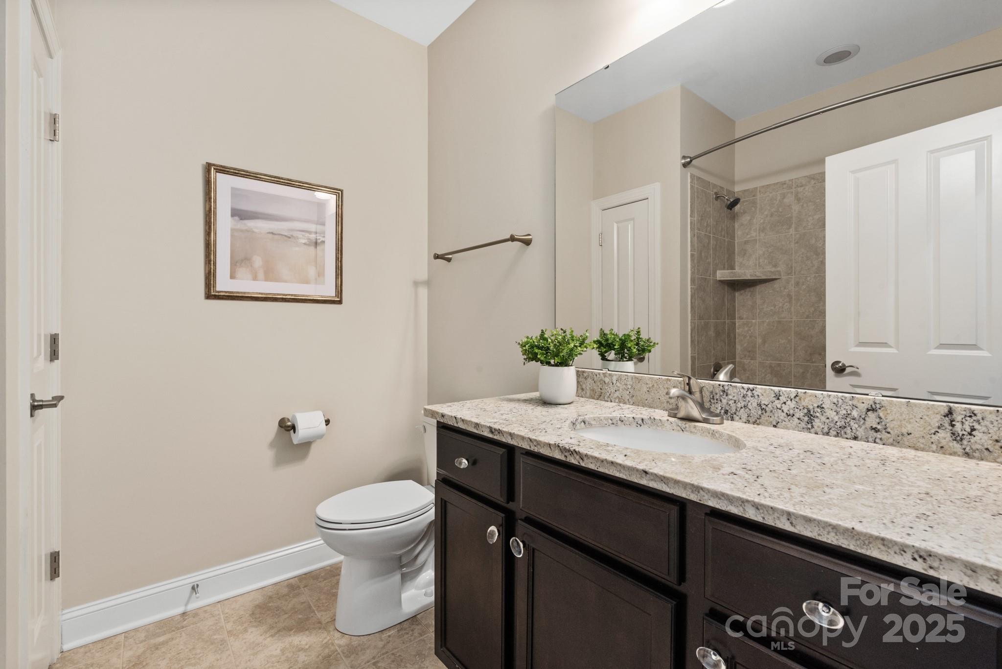 1128 Avalon Place Matthews, NC 28104 - Photo 26 of 39 a bathroom with a granite countertop sink a toilet and a mirror