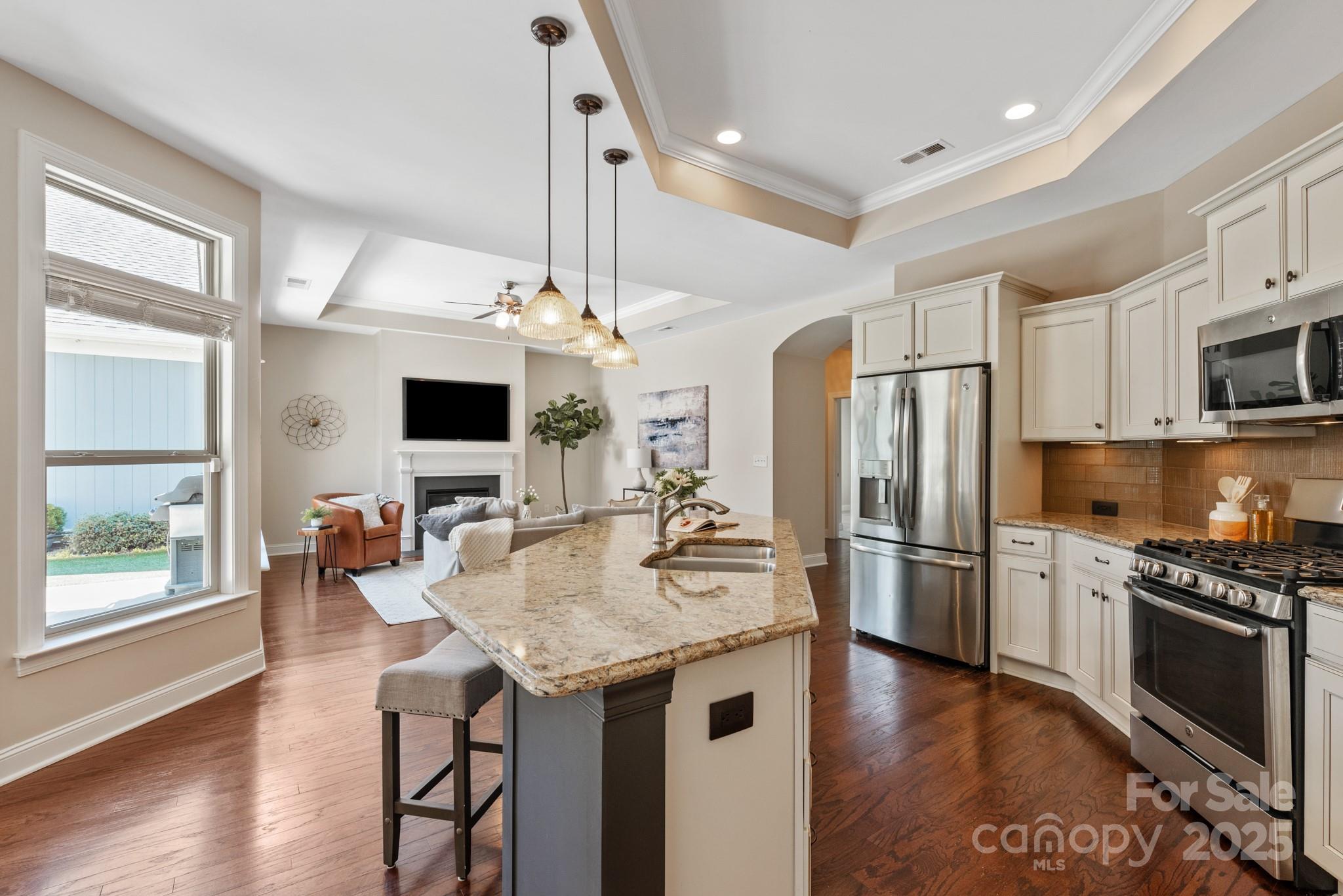 1128 Avalon Place Matthews, NC 28104 - Photo 10 of 39 a kitchen with stainless steel appliances kitchen island granite countertop a refrigerator a stove a sink dishwasher and a dining table with wooden floor