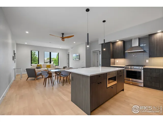 a kitchen with kitchen island a stove a counter top space and a dining table