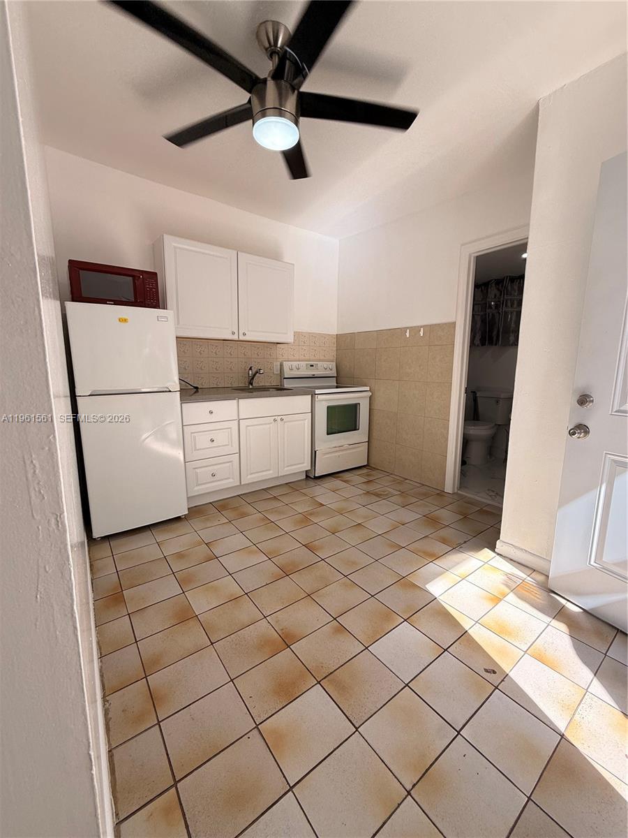 1037 Southwest 20th Avenue, Unit 2 Miami, FL 33135 - Photo 1 of 12 a kitchen with stainless steel appliances a refrigerator and a stove top oven