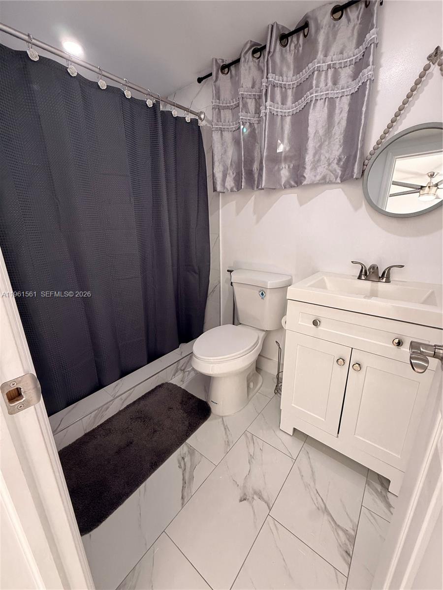 1037 Southwest 20th Avenue, Unit 2 Miami, FL 33135 - Photo 4 of 12 a bathroom with a sink a toilet a mirror and shower