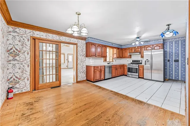 a view of a kitchen with a sink refrigerator and wooden floor