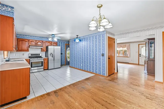 a large kitchen with stainless steel appliances granite countertop a stove sink and cabinets