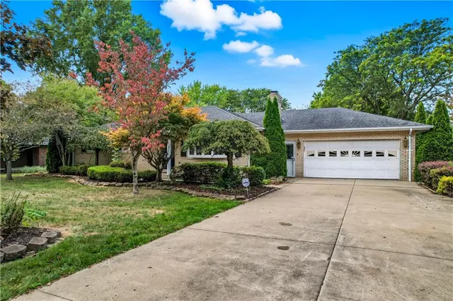 a view of a house with a yard and potted plants