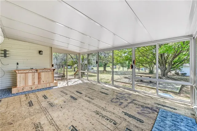 a view of an empty room with window and a ceiling fan