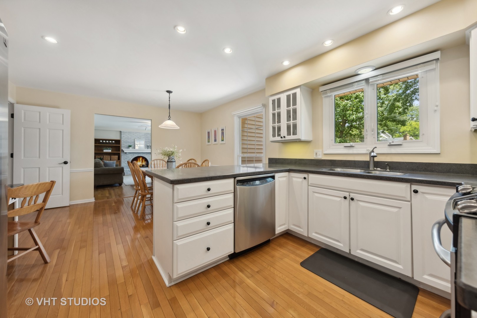 1589 Orth Drive Wheaton, IL 60189 - Photo 12 of 23 a kitchen with granite countertop a stove a sink and white cabinets with wooden floor