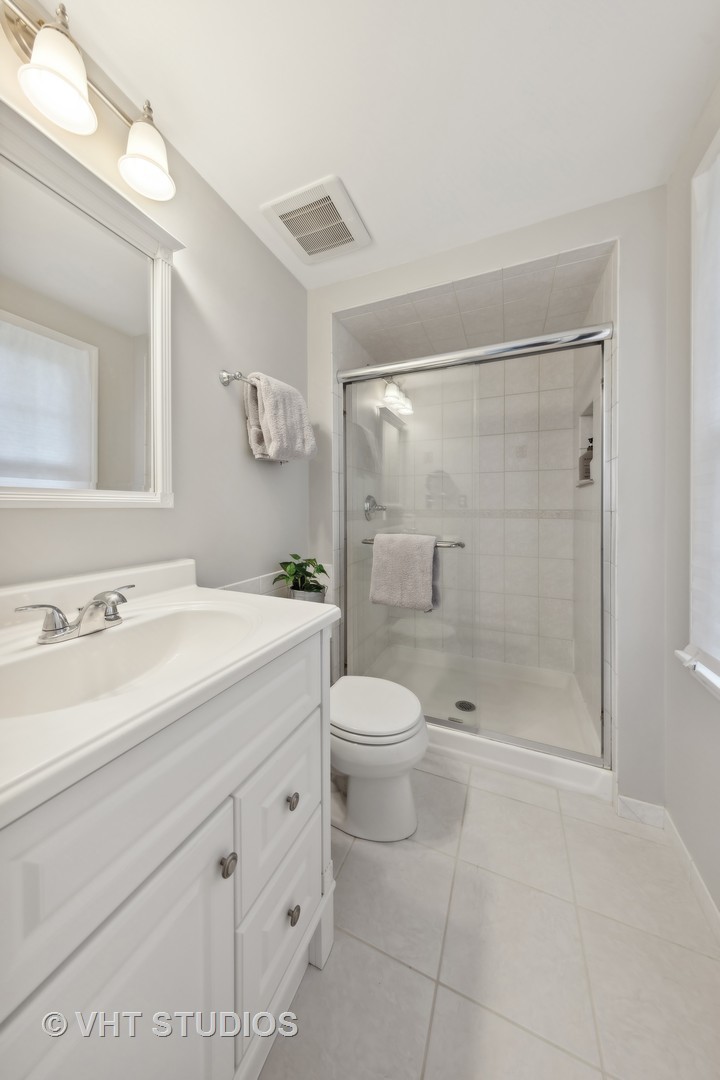 1589 Orth Drive Wheaton, IL 60189 - Photo 8 of 23 a bathroom with a shower sink vanity mirror and toilet