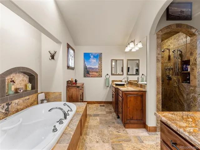 a large bathroom with a tub sink and mirror
