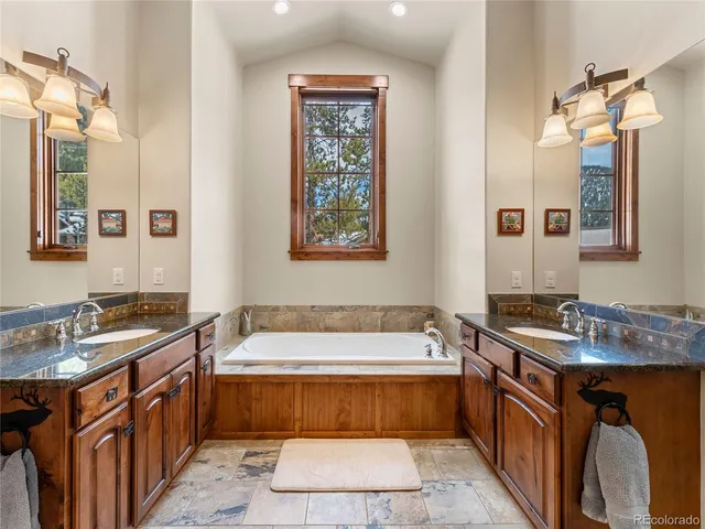 a bathroom with a tub sink and mirror