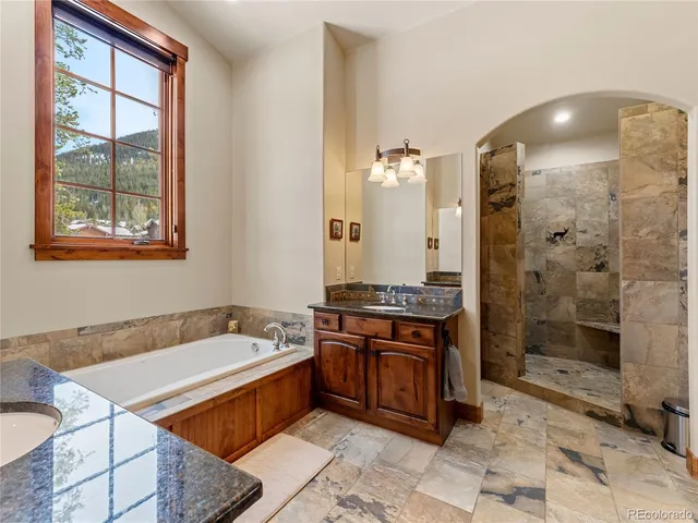 a spacious bathroom with a tub sink and shower