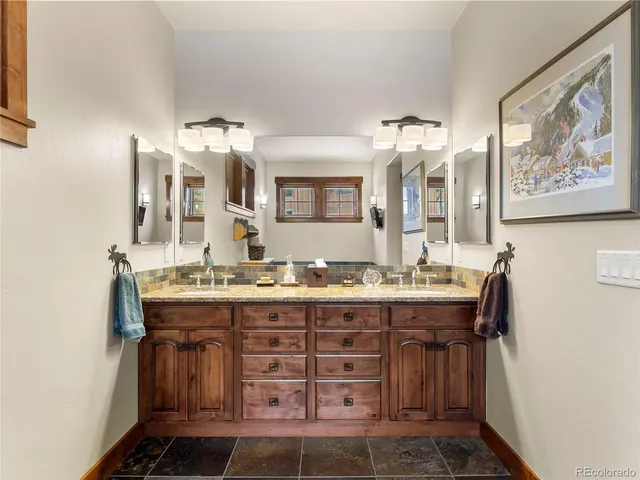 a bathroom with a granite countertop sink and a mirror