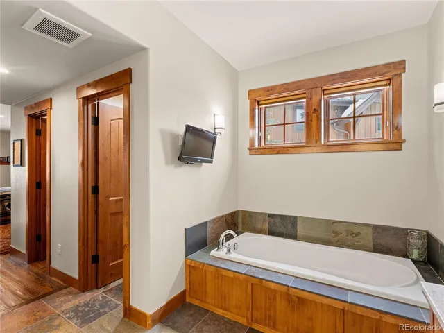 a bathroom with a tub a sink and a window