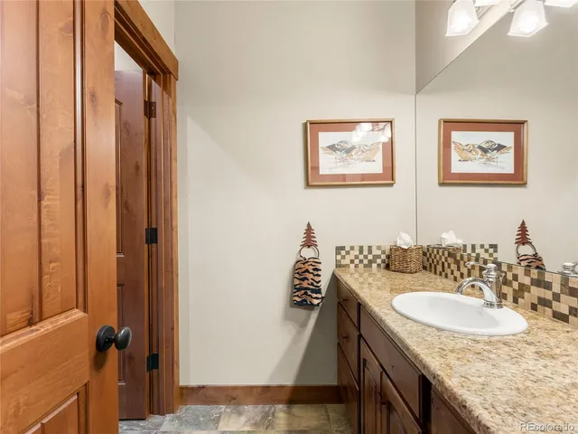 a bathroom with a granite countertop sink and a mirror