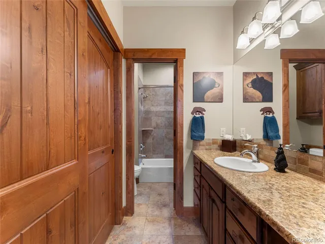 a bathroom with a granite countertop sink a mirror and shower