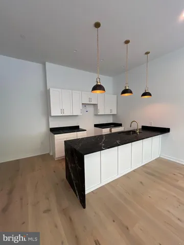 a kitchen with stainless steel appliances a stove a sink and white cabinets
