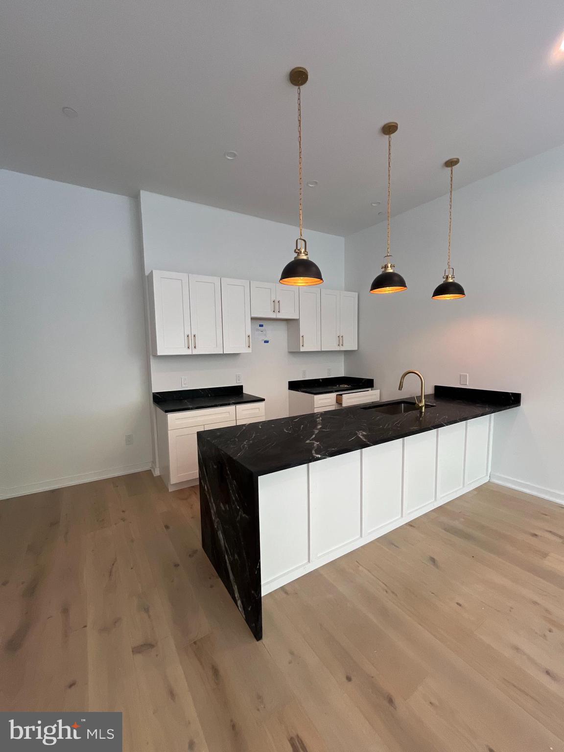 a kitchen with stainless steel appliances a stove a sink and white cabinets