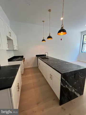 a kitchen with stainless steel appliances granite countertop a sink a stove and a wooden floors