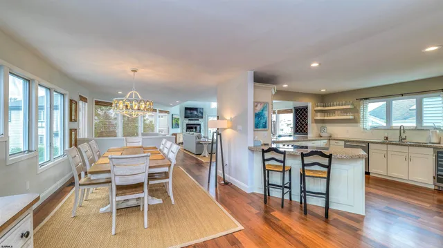 a dining room with stainless steel appliances kitchen island granite countertop a dining table chairs and granite counter tops