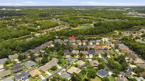 an aerial view of residential houses with outdoor space and trees