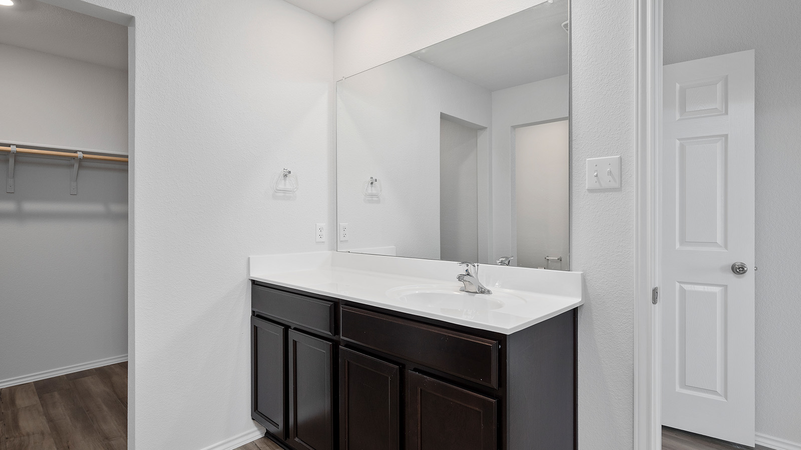 1312 Victory Rnch Trail Killeen, TX 76549 - Photo 13 of 22 Bathroom with vanity, dark wood-style floors, a spacious closet, and a textured wall