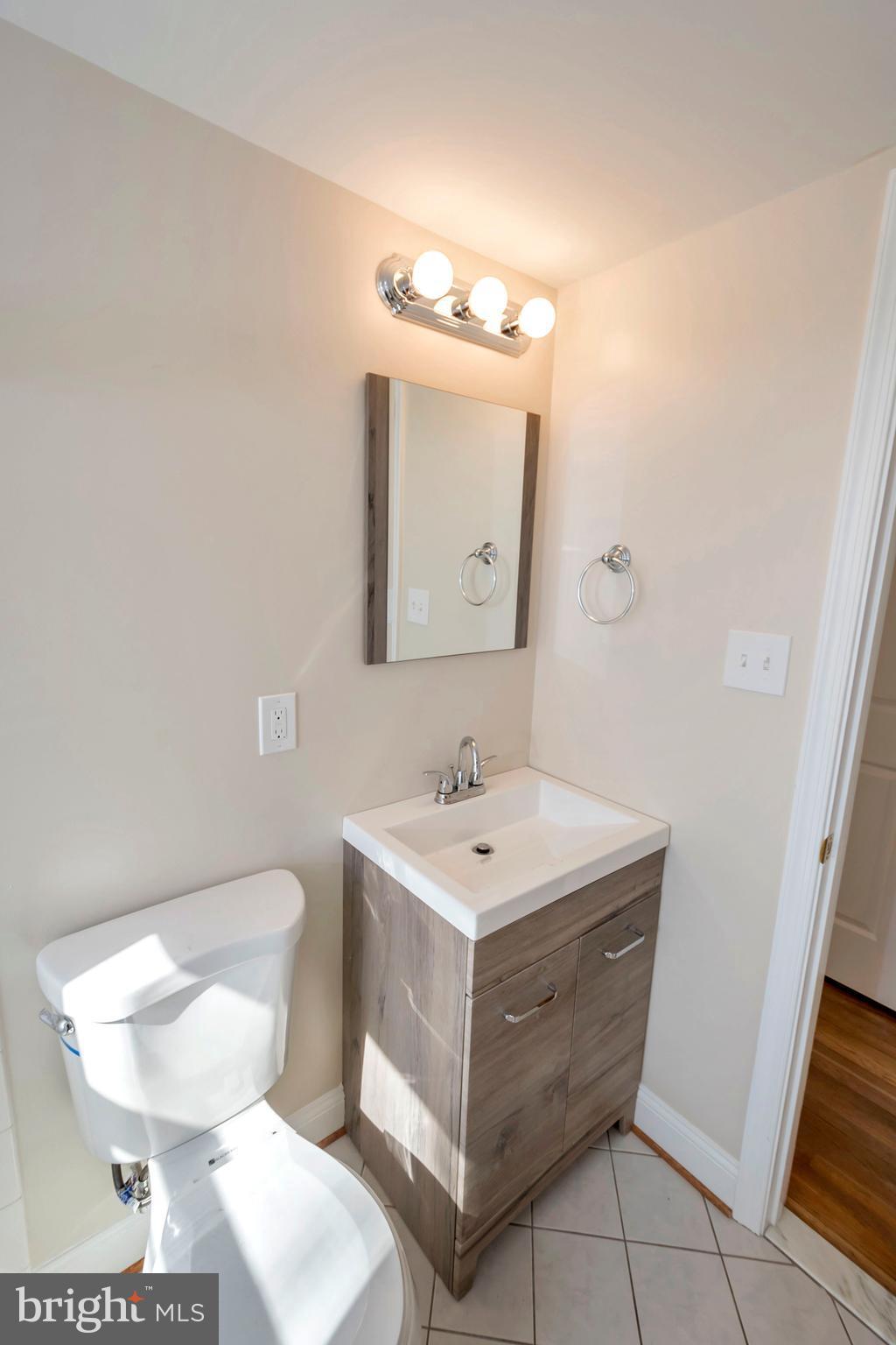 14114 Grayson Road Woodbridge, VA 22191 - Photo 12 of 28 a bathroom with a toilet a sink and mirror