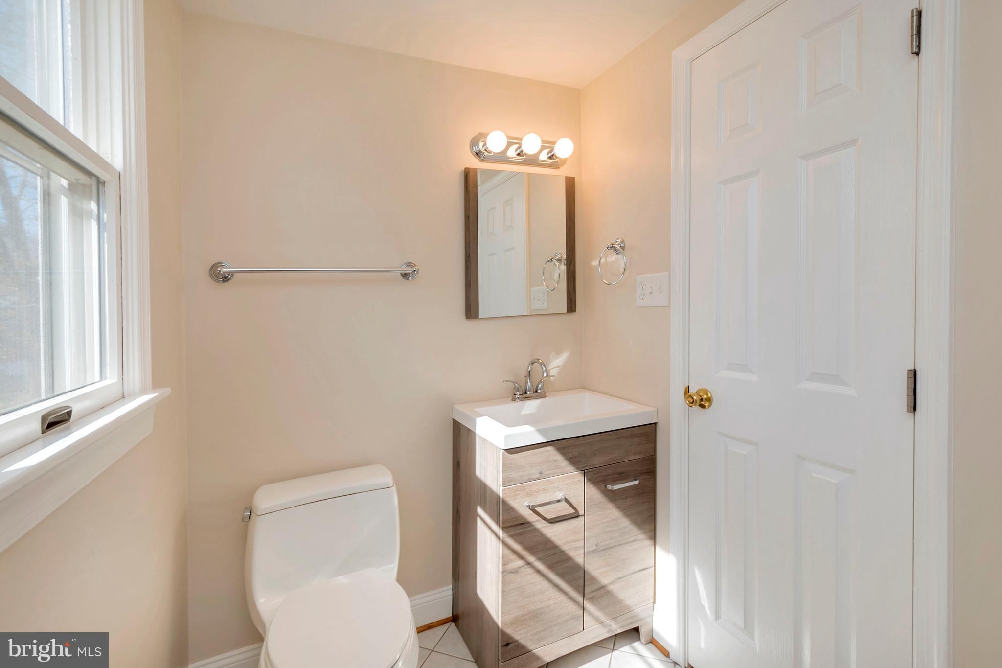 14114 Grayson Road Woodbridge, VA 22191 - Photo 21 of 28 a bathroom with a toilet a sink and mirror