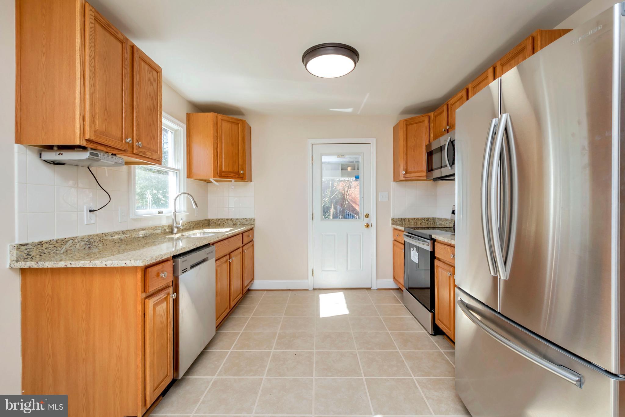 14114 Grayson Road Woodbridge, VA 22191 - Photo 7 of 28 a kitchen with stainless steel appliances granite countertop a refrigerator a stove and a sink