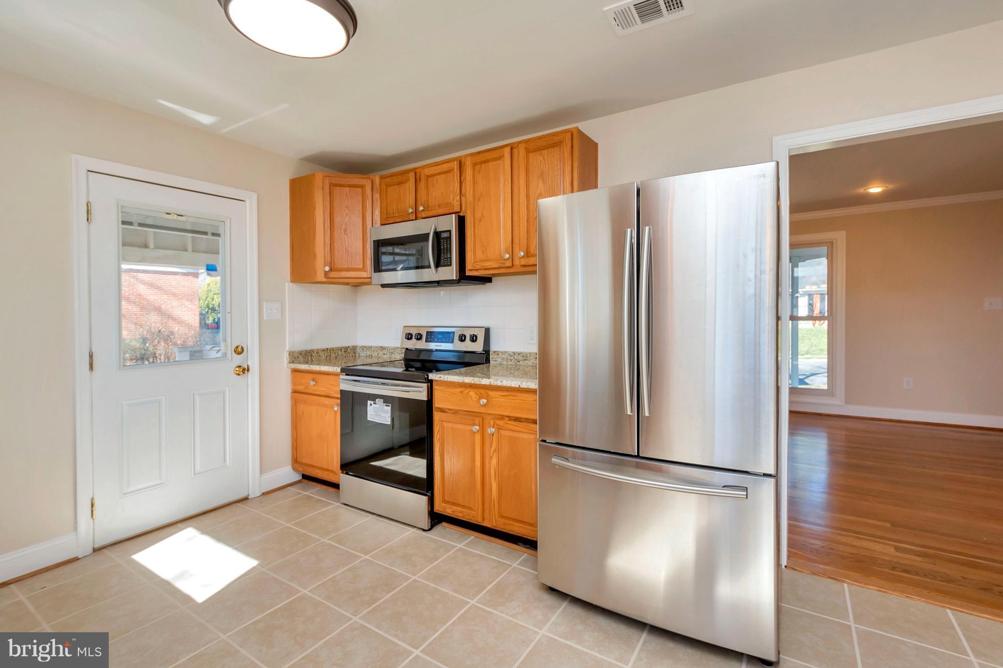 14114 Grayson Road Woodbridge, VA 22191 - Photo 9 of 28 a kitchen with stainless steel appliances granite countertop a refrigerator a stove top oven a sink and dishwasher