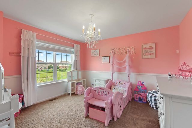 2050 Stapleton Road New Lenox, IL 60451 - Photo 27 of 38 a bedroom with a bed and a chandelier