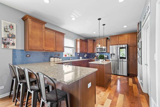 2050 Stapleton Road New Lenox, IL 60451 - Photo 5 of 38 a kitchen with stainless steel appliances granite countertop a stove a sink island and a refrigerator