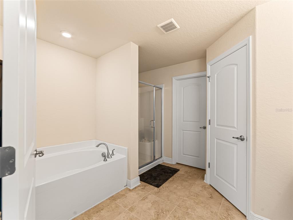 2412 Twin Lake View Road Winter Haven, FL 33881 - Photo 12 of 26 a bathroom with a bathtub and a shower