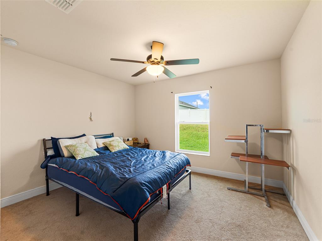 2412 Twin Lake View Road Winter Haven, FL 33881 - Photo 15 of 26 a bedroom with a bed and a chandelier