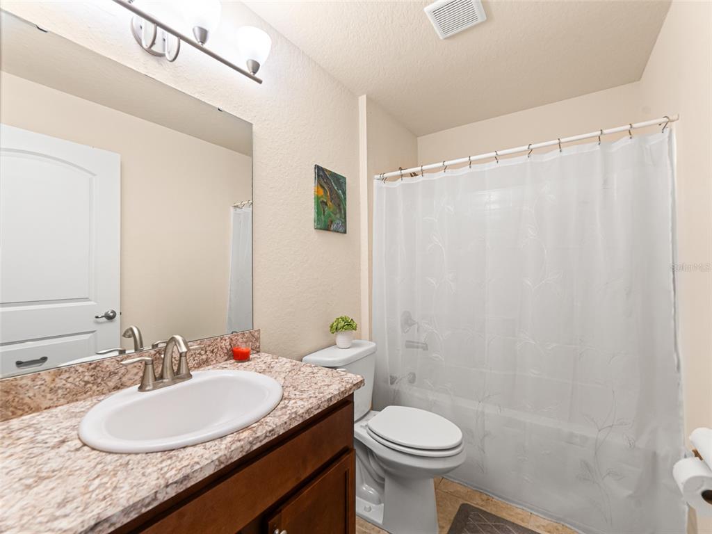 2412 Twin Lake View Road Winter Haven, FL 33881 - Photo 16 of 26 a bathroom with a granite countertop sink toilet and a mirror