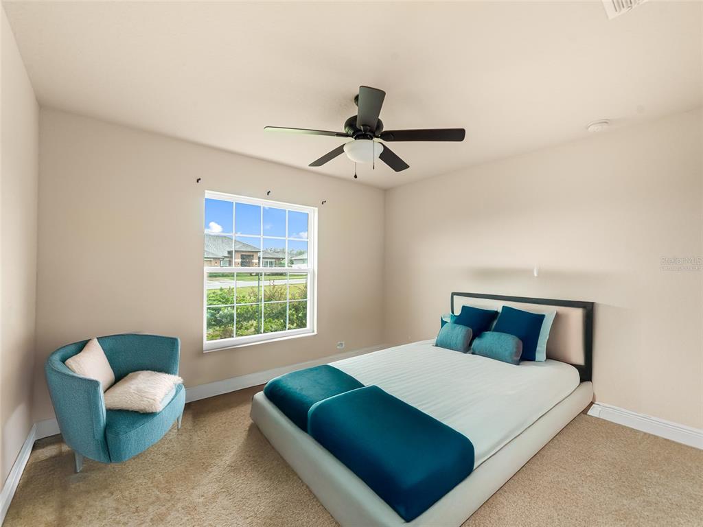 2412 Twin Lake View Road Winter Haven, FL 33881 - Photo 17 of 26 a bedroom with a bed a couch and a window