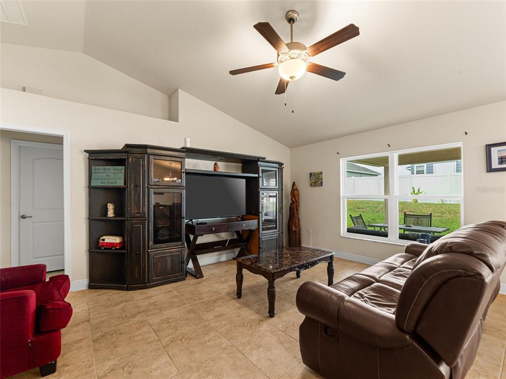 2412 Twin Lake View Road Winter Haven, FL 33881 - Photo 4 of 26 a living room with furniture a ceiling fan and a flat screen tv