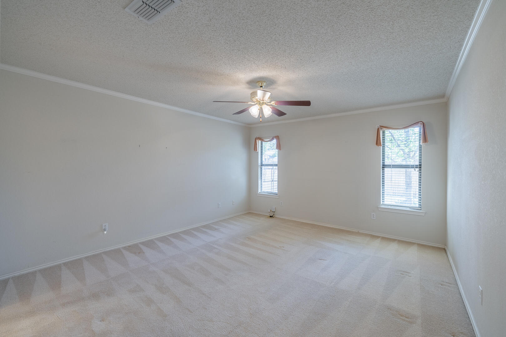 5415 68th Street Lubbock, TX 79424 - Photo 12 of 57 an empty room with a window and a chandelier fan
