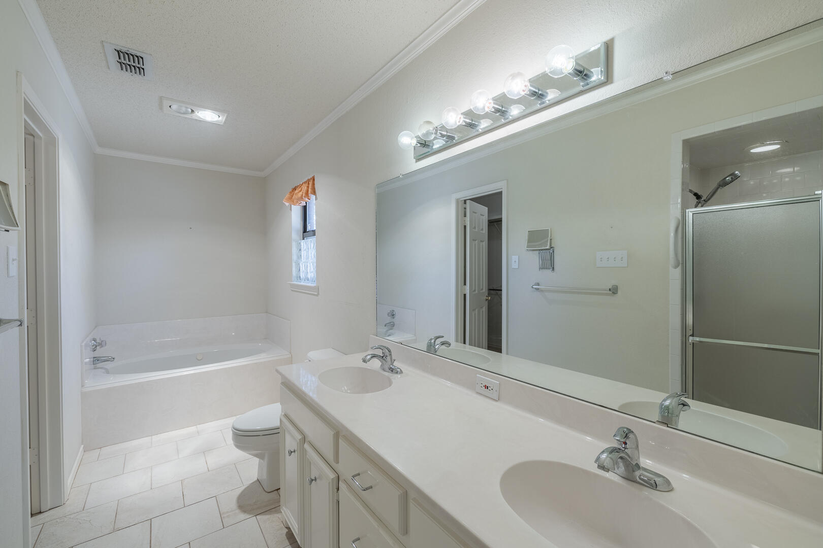 5415 68th Street Lubbock, TX 79424 - Photo 17 of 57 a bathroom with a bathtub double vanity sink and a mirror