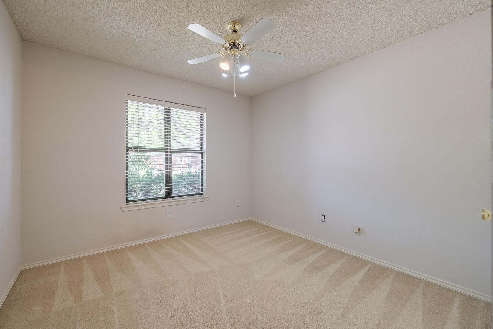 5415 68th Street Lubbock, TX 79424 - Photo 24 of 57 an empty room with a window and a ceiling fan